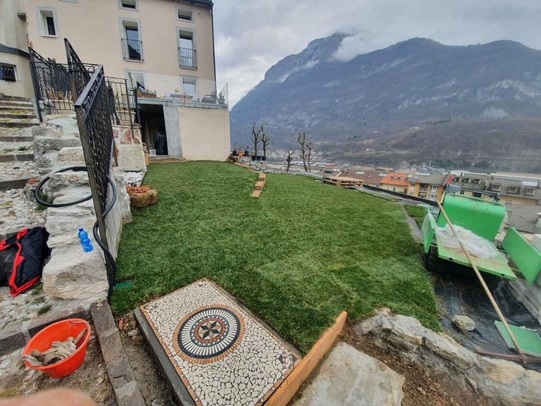 Giardino pensile sul tetto con erba sintetica verde e mosaico di piastrelle