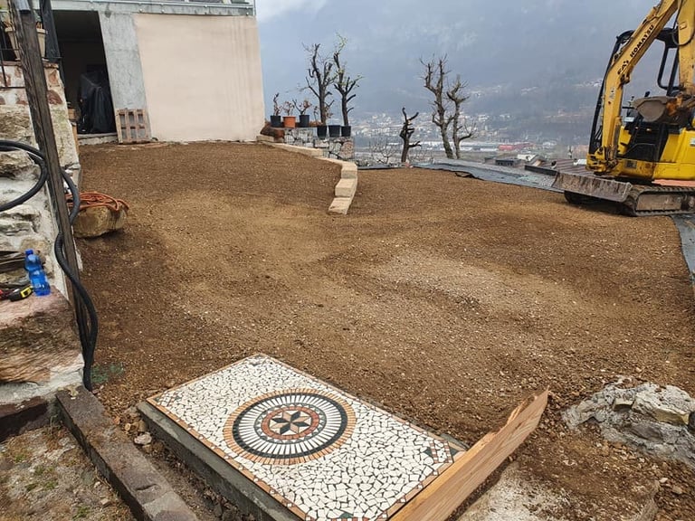 Cantiere edile su collina con escavatore e vista sulla città