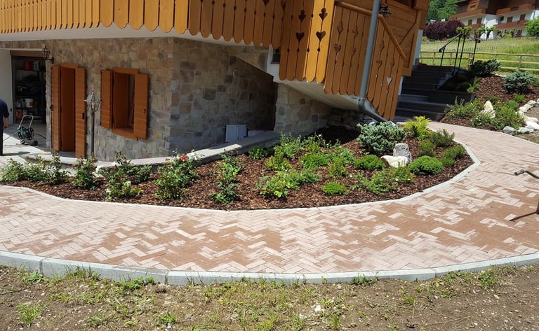 Edificio in pietra con tetto in legno e cortile con giardino