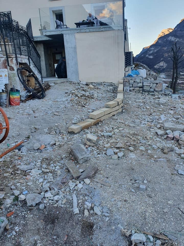 Costruzione edificio su terreno roccioso con montagne sullo sfondo